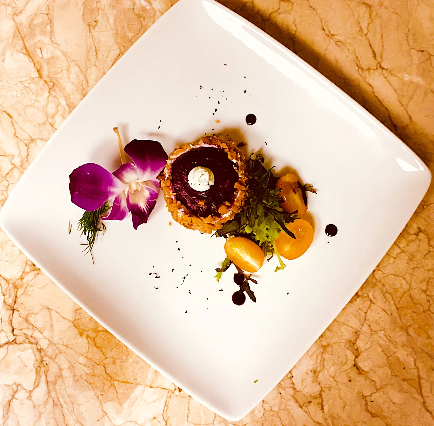 An artfully plated dish from Jenn Marr’s food gallery, finished with an orchid