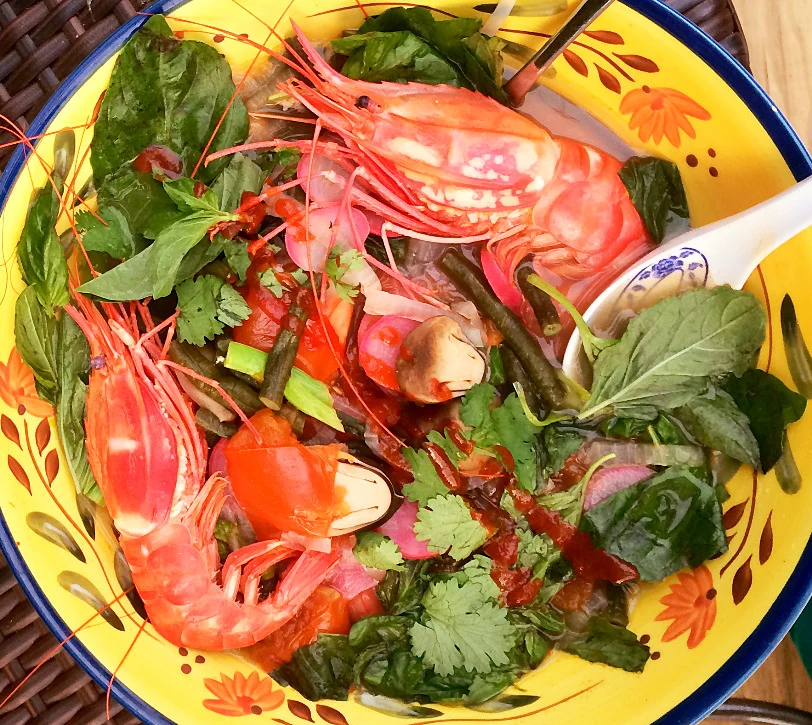 Prawns and fresh herbs in a colorful serving bowl